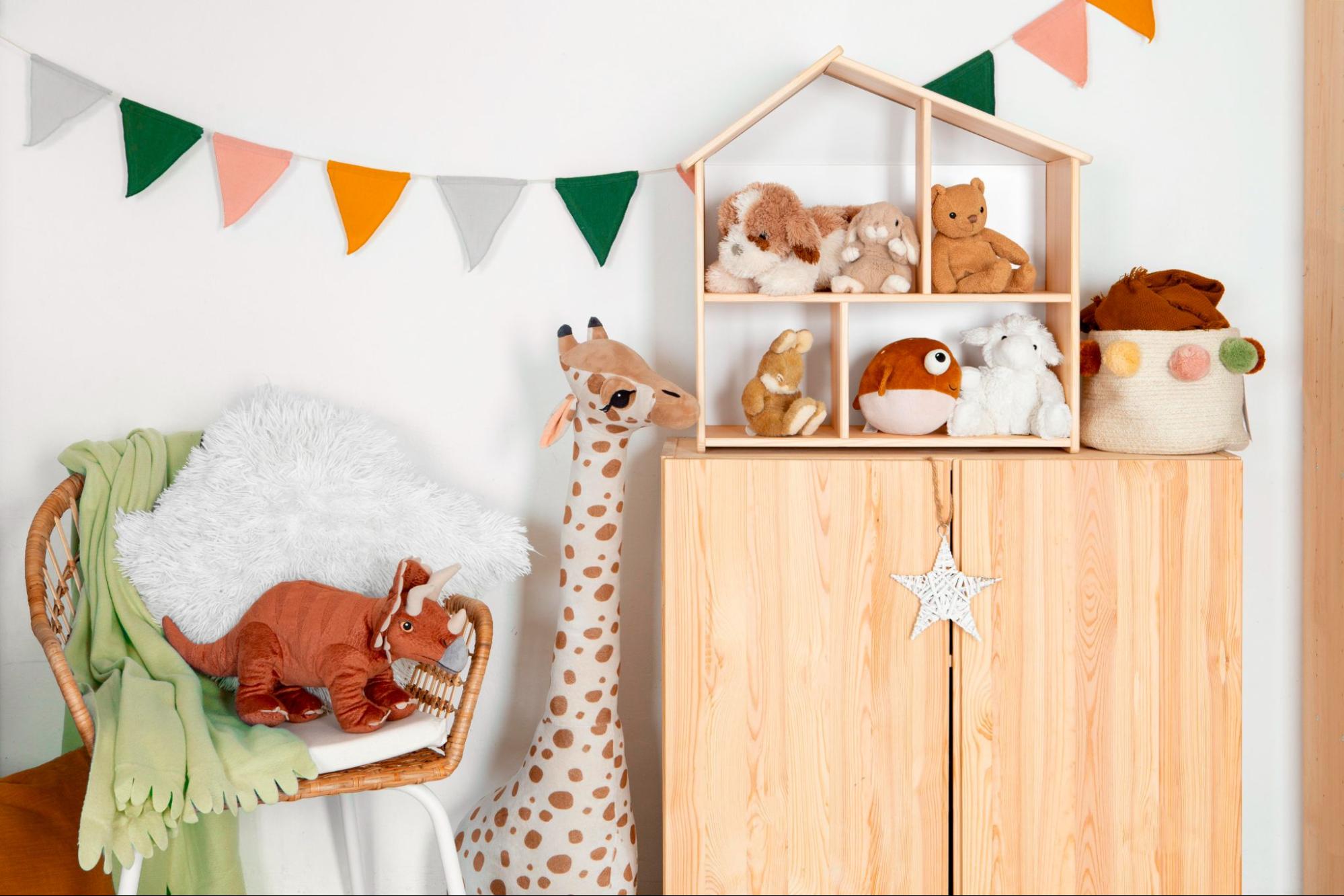 Nursery with plush toys and festive garland, a charming baby shower gift idea.