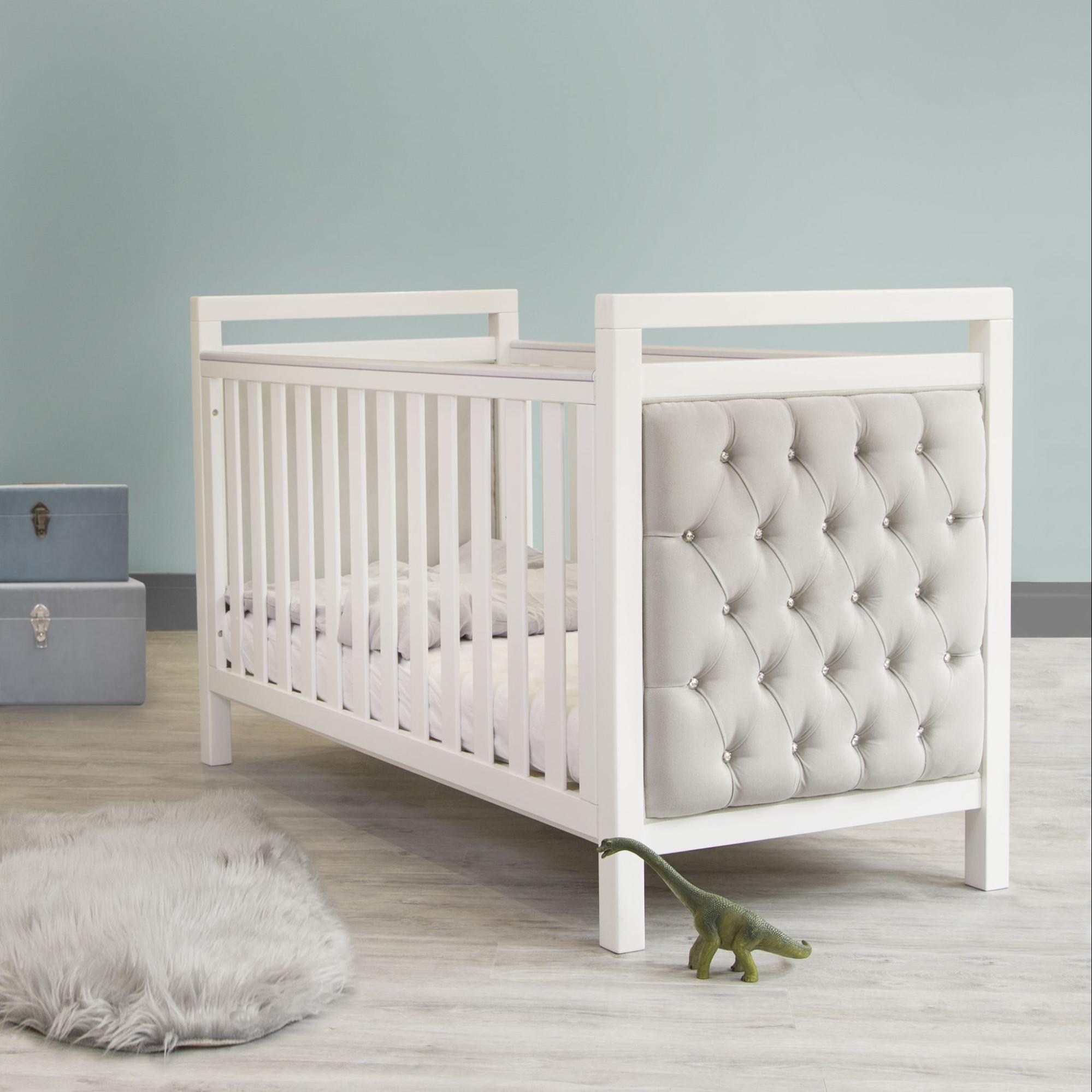 Elegant white travel crib in nursery room, a top baby shower gift idea