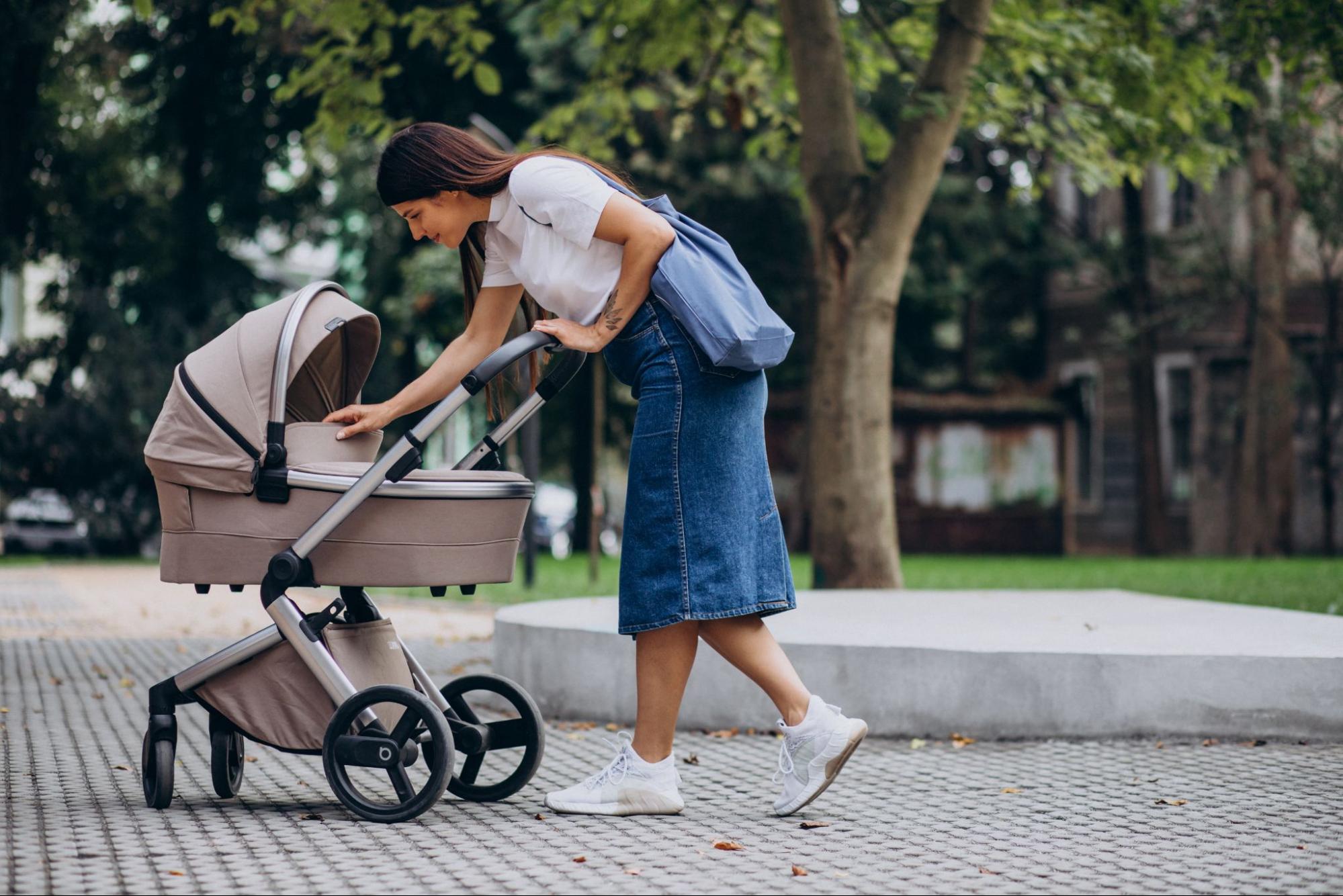 Woman with a stroller in a park, a stroller phone mount for baby shower gift ideas