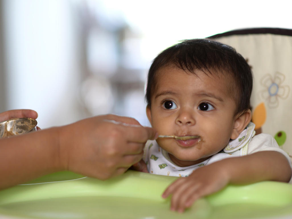 Baby eating from a spoon.