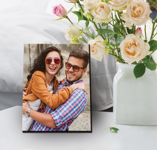 Tabletop canvas print of a joyful couple laughing, accompanied by a vase of roses, for Valentine's Day