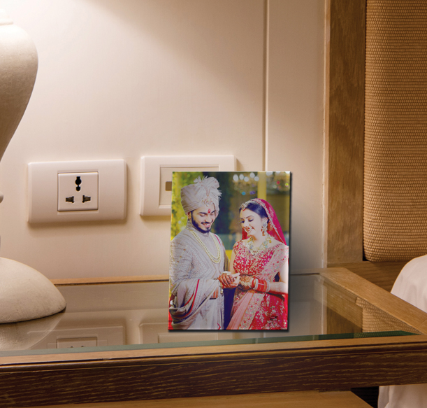 A personalized table frame showcasing a couple on a bed with a lamp.