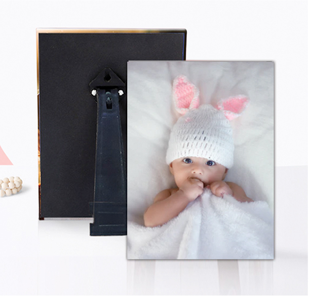 A cute baby donning a bunny hat, joyfully clutching a photo frame.
