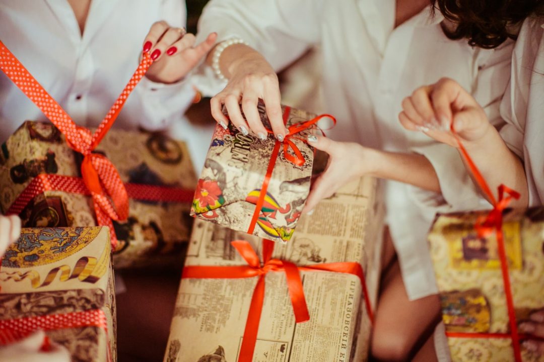 Hands tying a ribbon on a festive gift, suitable for wedding gift ideas