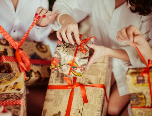 Hands tying a ribbon on a festive gift, suitable for wedding gift ideas