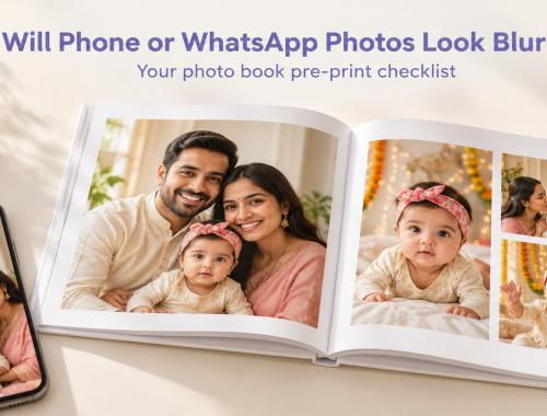 Smartphone beside an open white hardcover photo book displaying Indian family photographs.